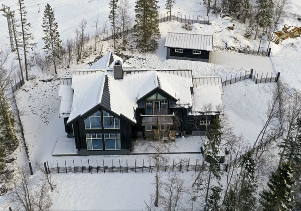 Timmerhus av BearPeak ramas in med gärdsgård.