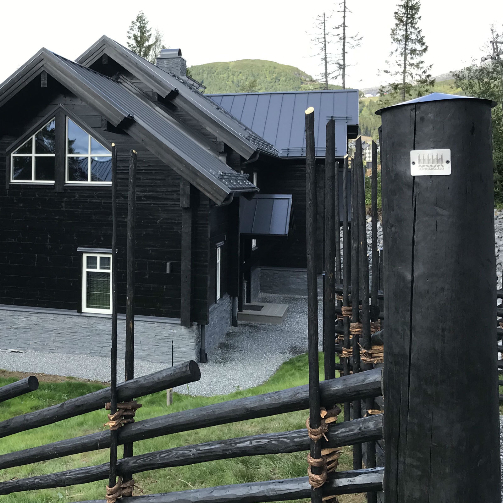 Svart trävilla i Sadeln, Åre med svarttjärad gärdsgård.